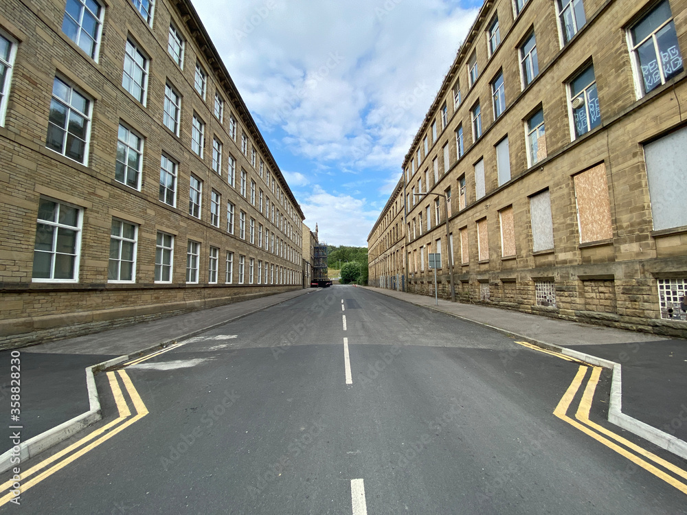 A road, running between two large Victorian mills in, Cape Street, Bradford, UK