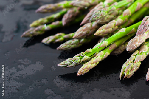 Green asparagus on a black background to restore the muscles of athletes and for the diet of girls. Balanced diet.