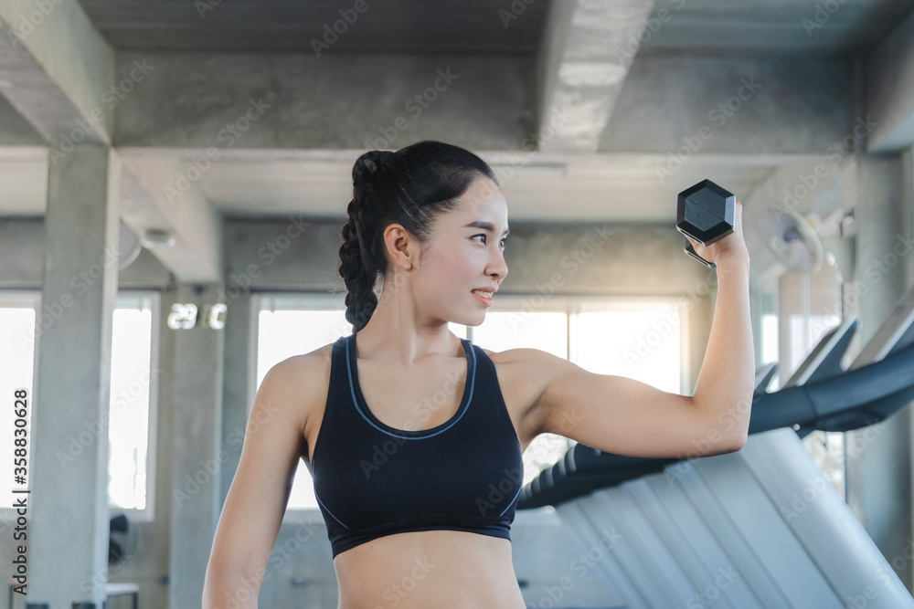Asian women are beautiful, charming weight Training Lift dumbbells With a strong body in gym Asian women are beautiful, charming weight Training Lift dumbbells With a strong body in gym