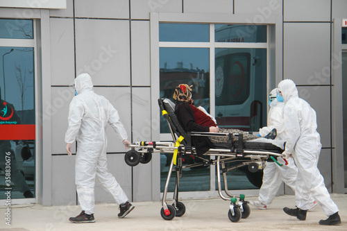 Paramedics carrying a woman for COVID-19, a covid-positive woman on stretcher, fight against the pandemic photo