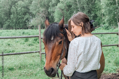 Young woman with horse in nature. back Brunette girl and horse © epovdima