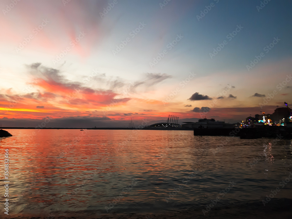 Genova, Italy - 06/18/2020: Beautiful photography of the sunset over the sea and clouds reflection on the water. Panoramic view to the ligurian coast in spring days.