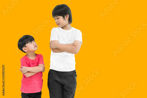 Little child boy and tall child boy standing arms crossed and looking face