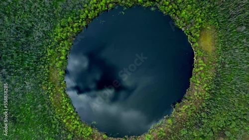 Lake Bezdonnoe in Moskovskaya oblast' shot from drone. Drone aerial shot zoom out of green trees in Moskovskaya oblast with a view over a round circle lake bezdonnoe, botomless lake in Russia