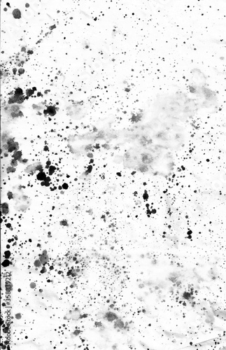 Black ink stains, dots, spatter and splashes on white paper background photo