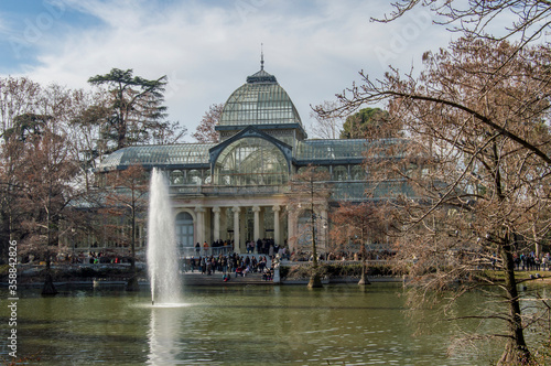 an image of the Crystal Palace with the pond in front on an autumn day in the Retiro Park in Madrid. Spain.
