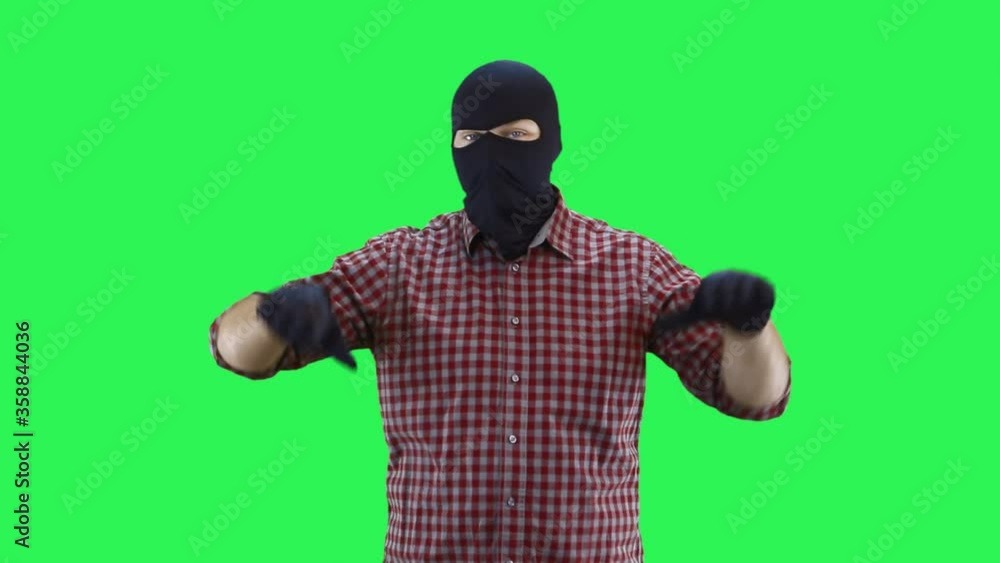 A man in a balaclava in a plaid shirt shows with two hands that everything is bad. A man in a balaclava in a plaid shirt shows with two hands that everything is bad.