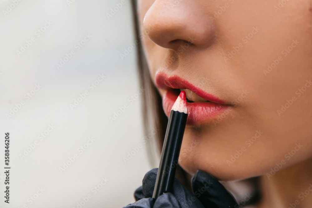 red pencil applied to beautiful lips