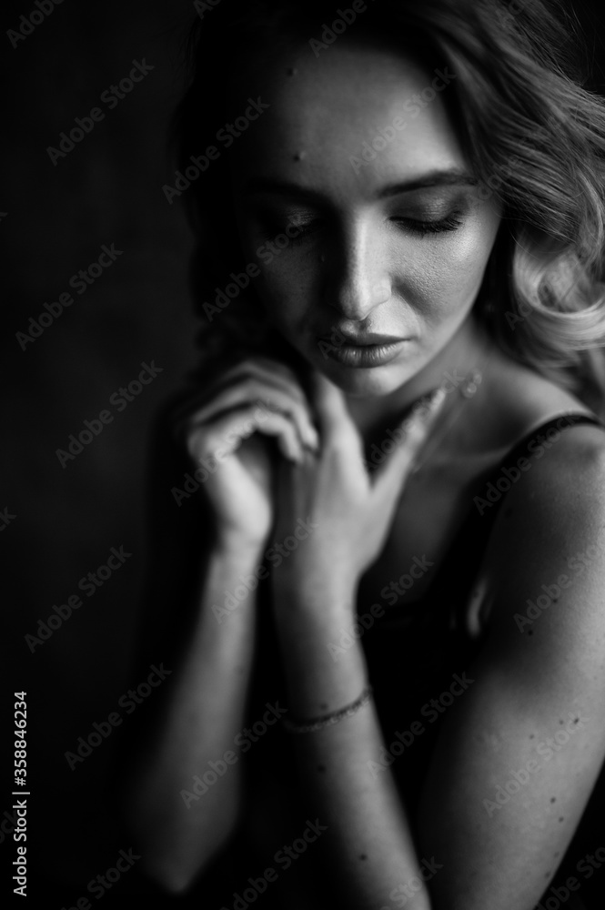 Close up monochrome portrait of curly blond charming woman.