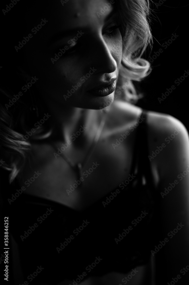 Close up monochrome portrait of curly blond charming woman.