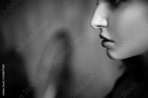 Close up monochrome portrait of curly blond charming woman with cool lips.