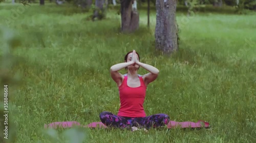 Yoga girl practicing breathing technique exercise with hands raised outdoors in park or garden. Maintaining flexibility and stability in the hip joints is crucial for lower-back health. Prores 422. 