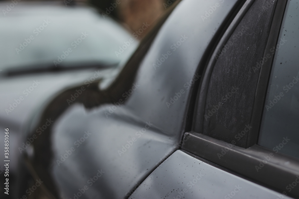 Obraz premium View of the cars C pillar from the outside. Unbranded black car shining on a cold wet day