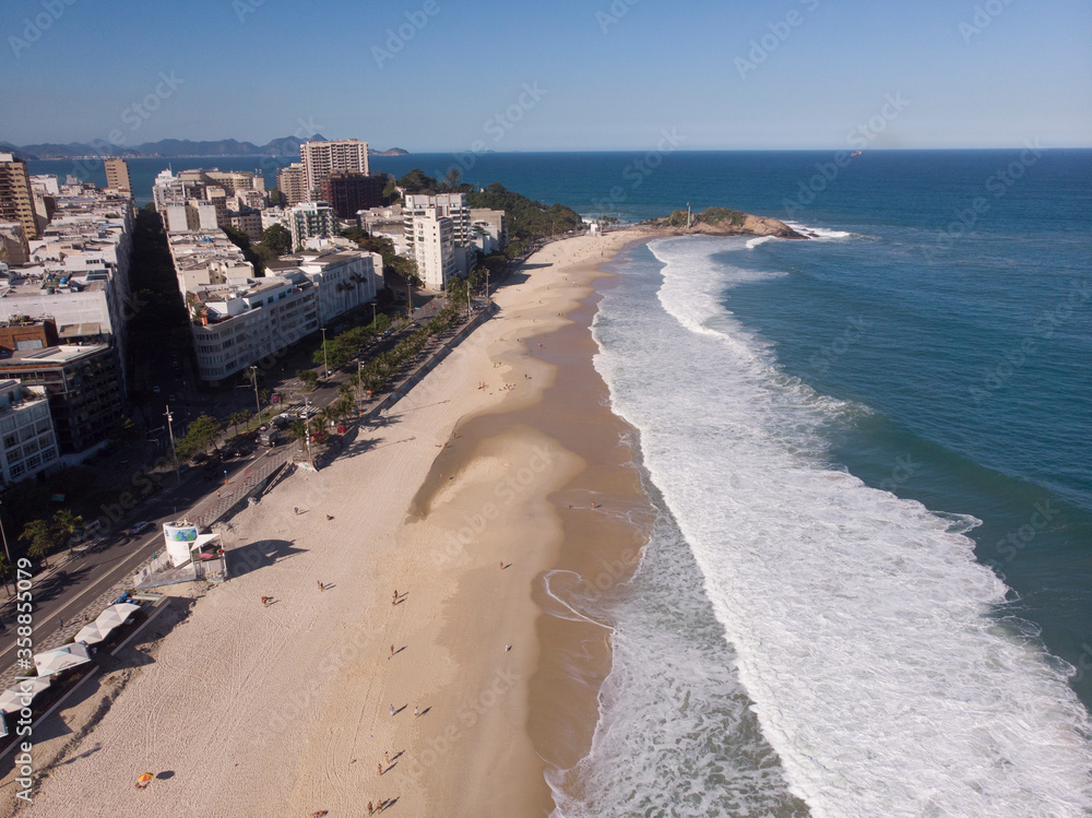 Ipanema beach and neighbourhood seen from above with Arpoador rock in the background at late afternoon. Aerial cityscape of Rio de Janeiro.