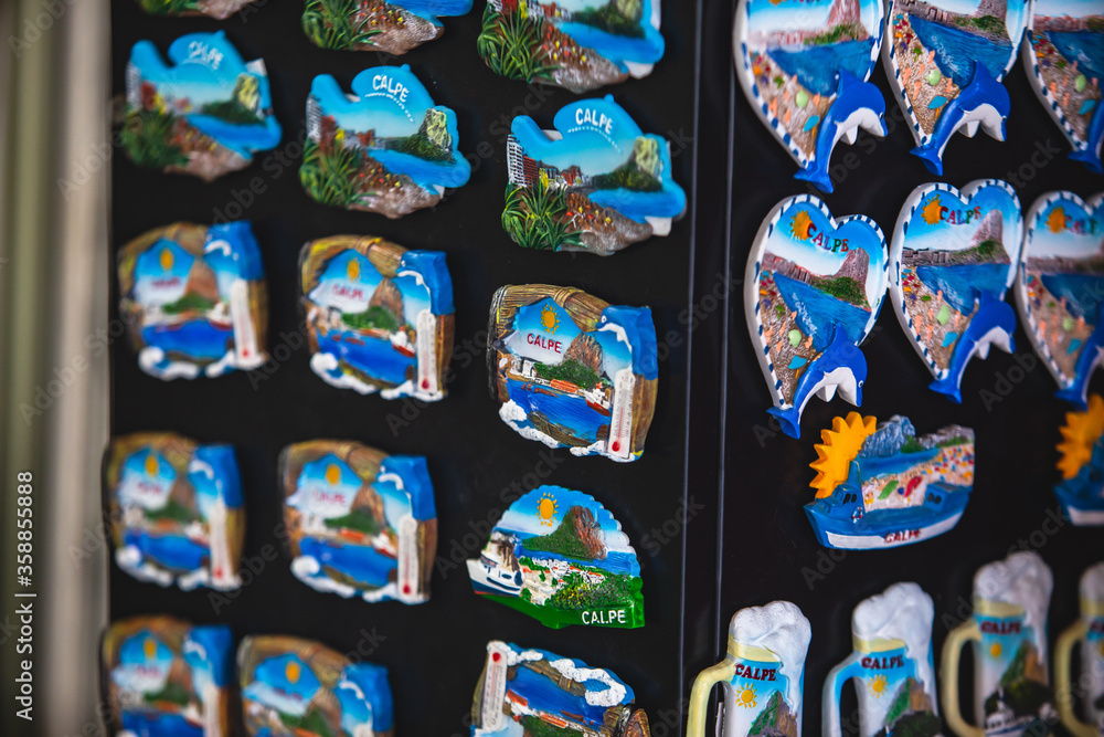 Obraz premium View of traditional tourist souvenirs and gifts from Calpe, Calp, Alicante, Valencia with toys, fridge magnets with and key ring keychain, in local vendor souvenir shop