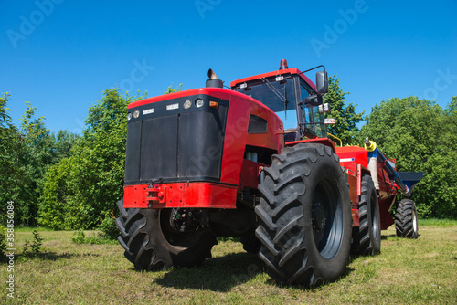 Tractor New Holland  on the field in the Russian village  on a Sunny day and blue sky. Russia. Tatarstan. 8 July 2019. Agricultural machinery.