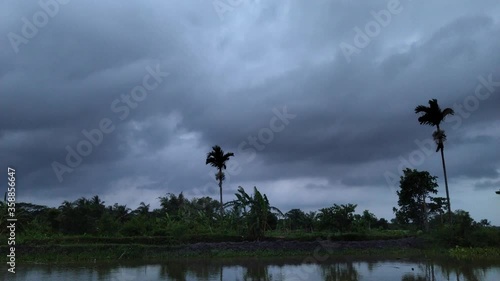 Dark Clouds Timelapse With trees in Stormy Wind over the lake