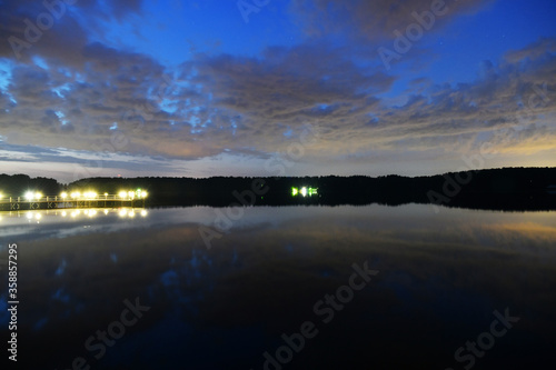 landscape with bright clouds and with reflections in the river before dawn