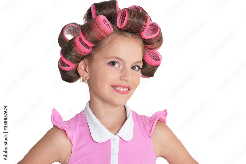 Close up portrait of little pretty girl with hair curlers posing