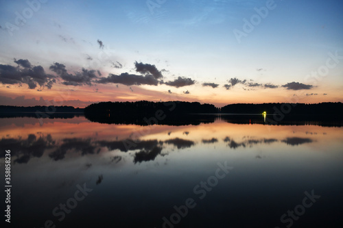 landscape with bright clouds and with reflections in the river before dawn