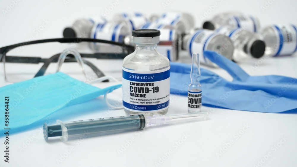 Obraz premium Covid-19 Corona Virus 2019-ncov Vaccine vials medicine drug ampoule bottle syringe injection medical nitrile gloves mask glasses. Vaccination, treatment to cure Covid 19 Corona Virus infection.
