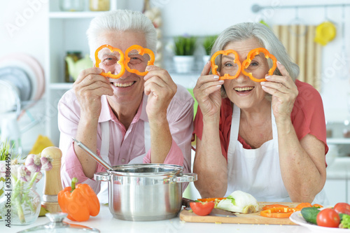 Portrait of senior couple cooking together at kitchen