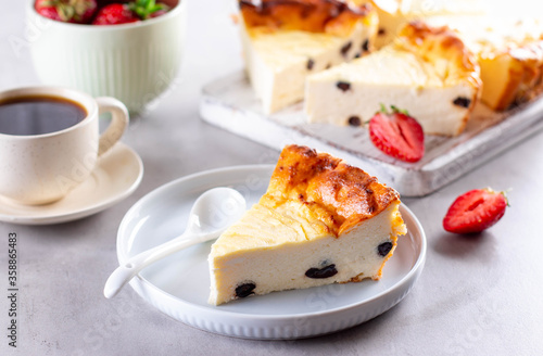 Cottage cheese casserole with raisins and strawberries on gray cement background