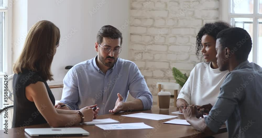 Diverse business team people working in teamwork talk discuss project strategy sit at conference room table, male mentor manager consult executive group training staff workers at corporate meeting Diverse business team people working in teamwork talk discuss project strategy sit at conference room table, male mentor manager consult executive group training staff workers at corporate meeting