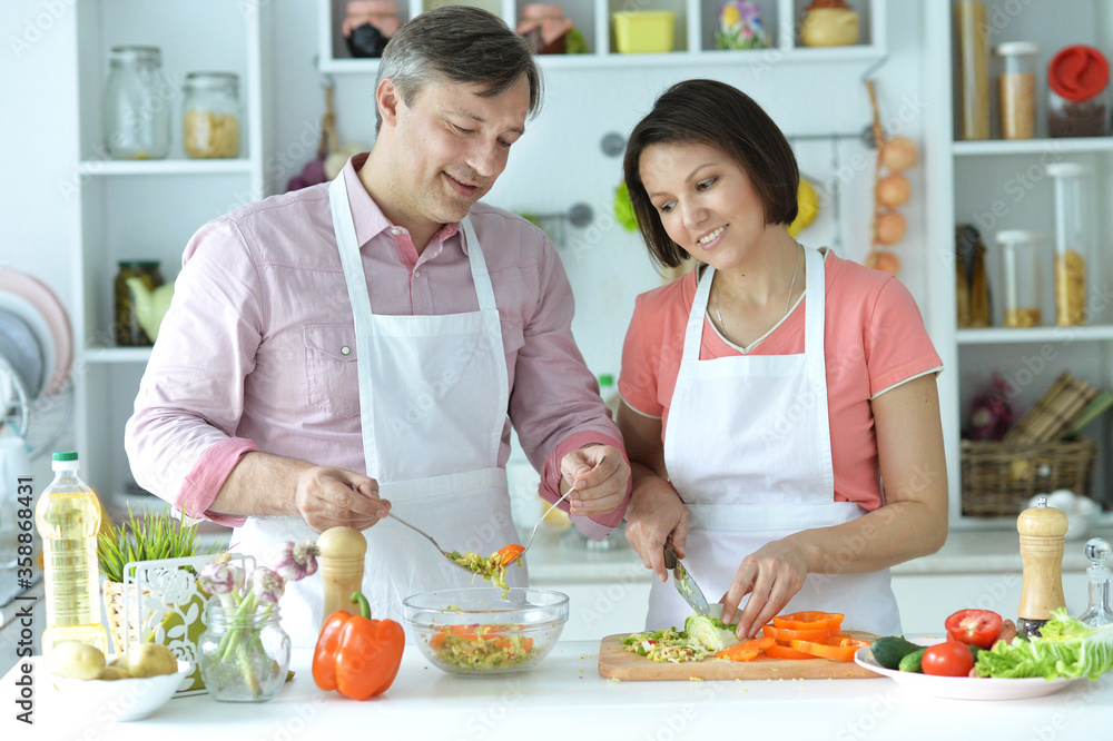 Happy husband and wife cooking together in the kitchen