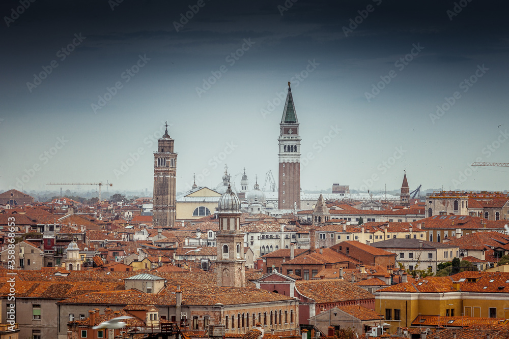 Aerial panorama of venetian bell towers and houses in a cloudy day, Venice, Italy