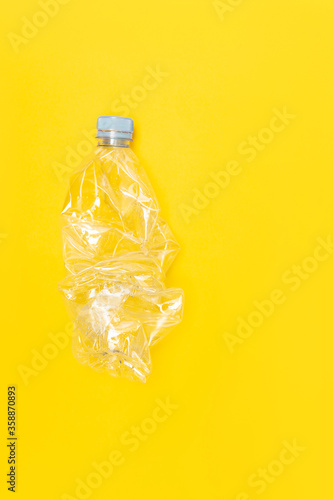 Used plastic bottle for recycling, on a yellow background, conceptual image with copy space