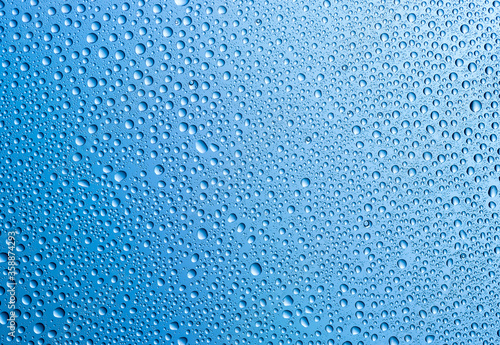 Background of water drops on gradient blue surface.