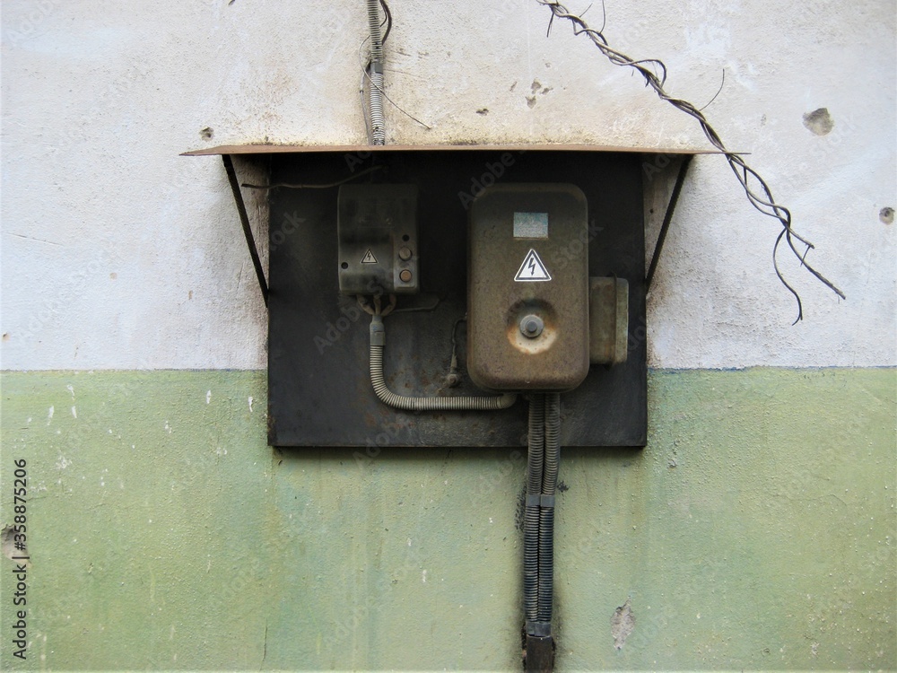 an old rusty electrical panel on a scuffed building wall an old rusty electrical panel on a scuffed building wall