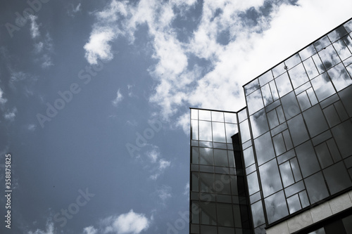 modern corporate building with clouds reflecting in the glass