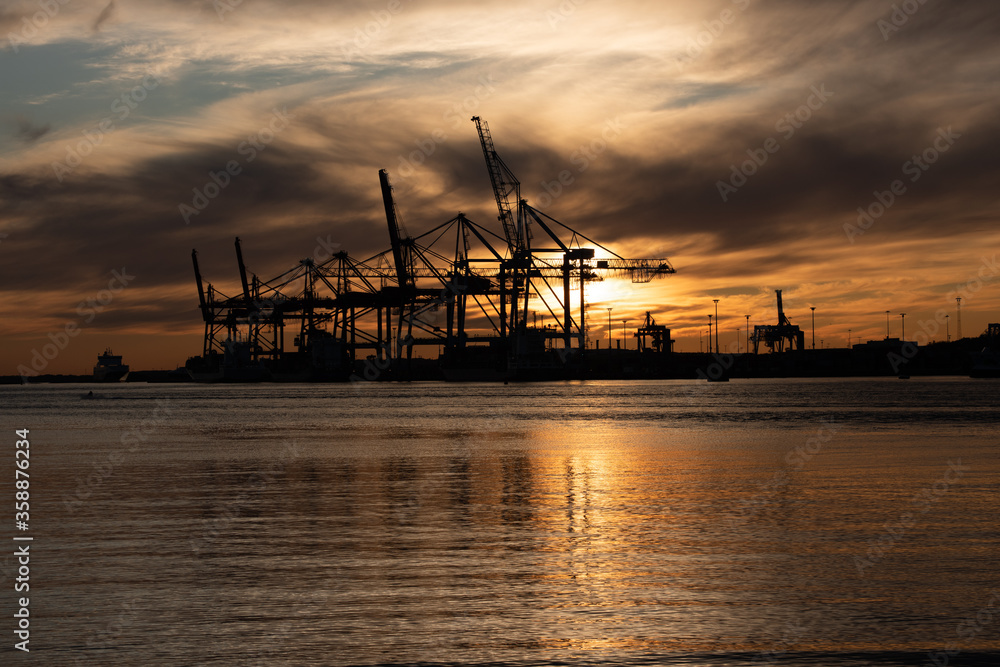 Silhouettes of ship to shore cranes at sunset.