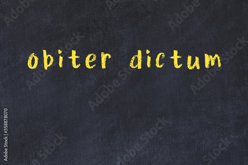Black chalkboard with inscription obiter dictum on in photo