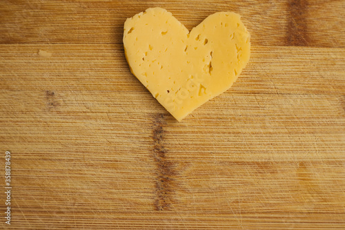 Cheese in the shape of a heart on a wooden Board. Grated cheese in the shape of a heart.