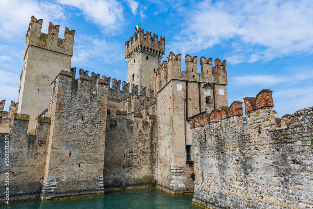 Rocca Scaligera castle in Sirmione with blue cloudy sky on the background
