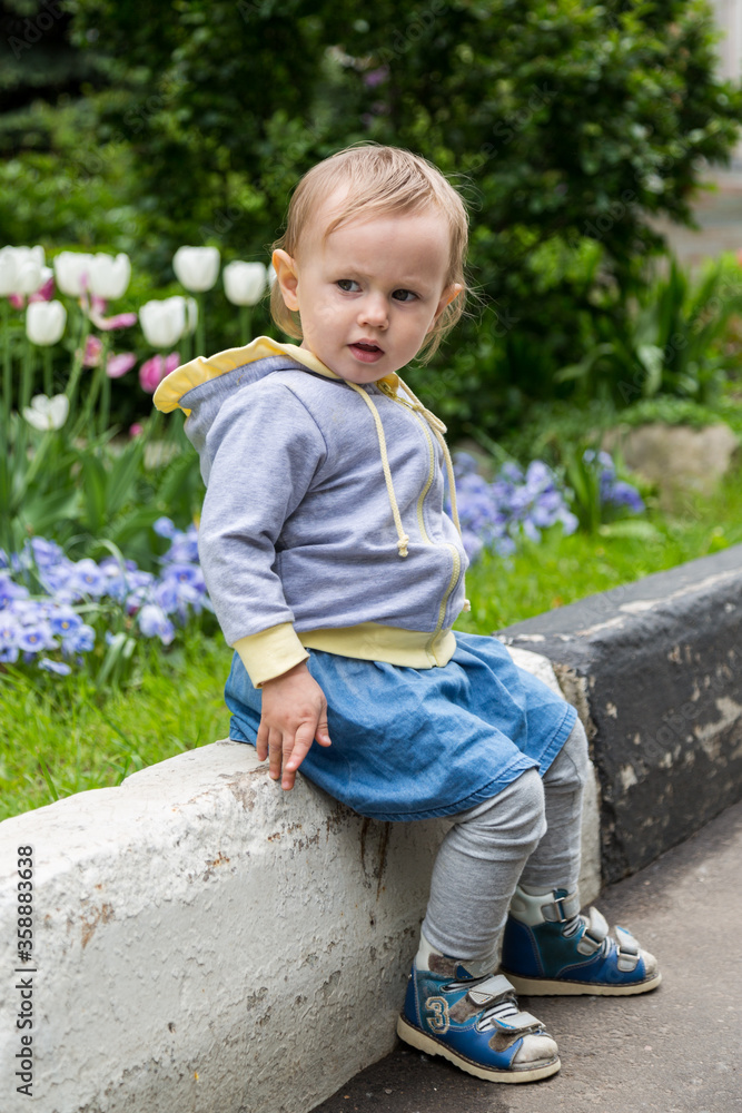 Young blonde girl standing on the green grass. Young blonde girl standing on the green grass.