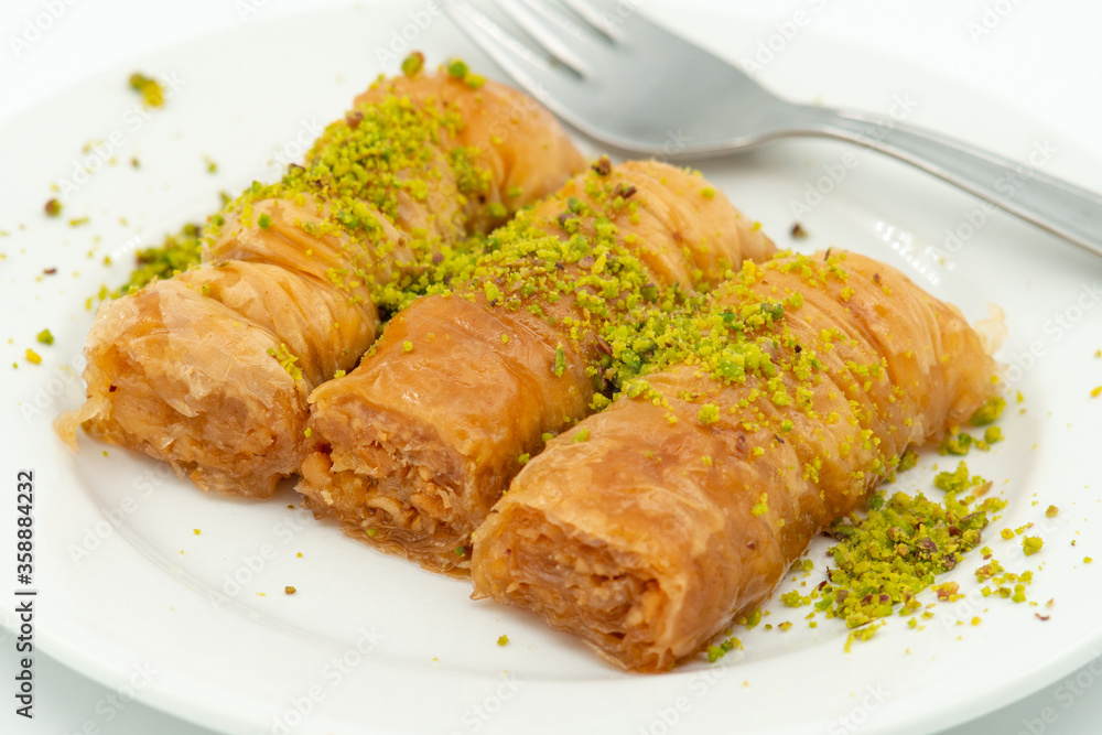 Three slices of Turkish baklava on a white plate, close up Three slices of Turkish baklava on a white plate, close up