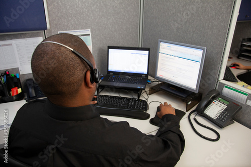 Canvas Print young man with computer and headset shot from behind