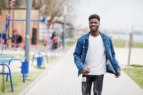 Young millennial african boy in city. Happy black man in jeans jacket. Generation Z concept.