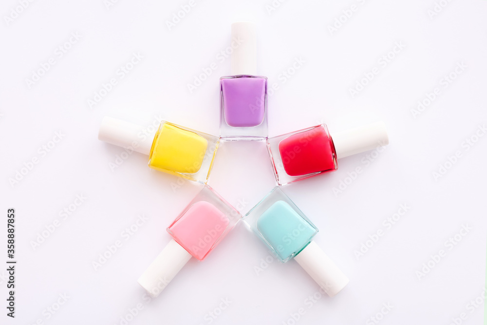 Group of nail polishes of different colors in shape of star on white background. Top view Group of nail polishes of different colors in shape of star on white background. Top view