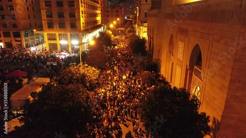 Beirut, Lebanon 2019 : night drone shot ped up from road leading to Riyadh El Soleh square then revealing church and mosque while thousands of protesters are revolting during the Lebanese revolution photo