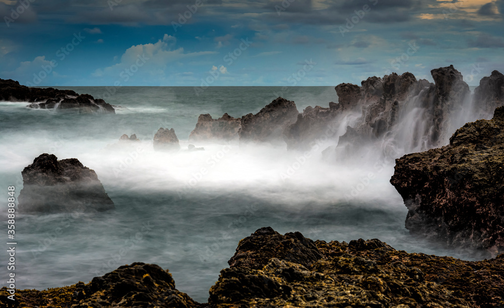 Silky seawater wave in Siung beach, Java Island, Indonesia. This beach consisted of paleo volcanic rocks Silky seawater wave in Siung beach, Java Island, Indonesia. This beach consisted of paleo volcanic rocks