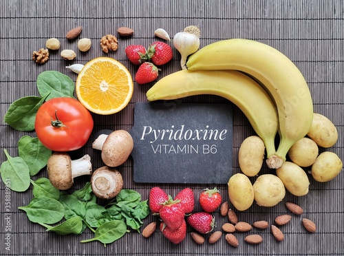 Foods rich in vitamin B6 (Pyridoxine). Assortment of fresh fruit and vegetable high in vitamin B6. Natural sources of vitamin B6: banana, potato, mushroom, tomato, garlic, spinach, almond, strawberry. photo