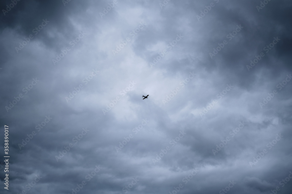 airplane on the grey stormy skies. Small airplane on the sky.
