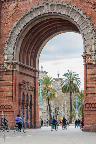 People on a bike tour at the Triumphal Arch in Barcelona Spain