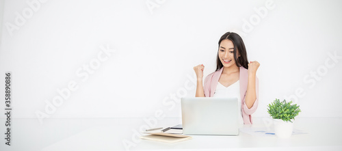 Portrait of smiling beautiful business asian woman with pink suit working in office desk using computer. Small business people employee freelance online sme marketing  telemarketing successful banner