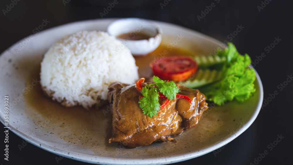 Rice with Roast Chicken in a white plate on a black table. Rice with Roast Chicken in a white plate on a black table.